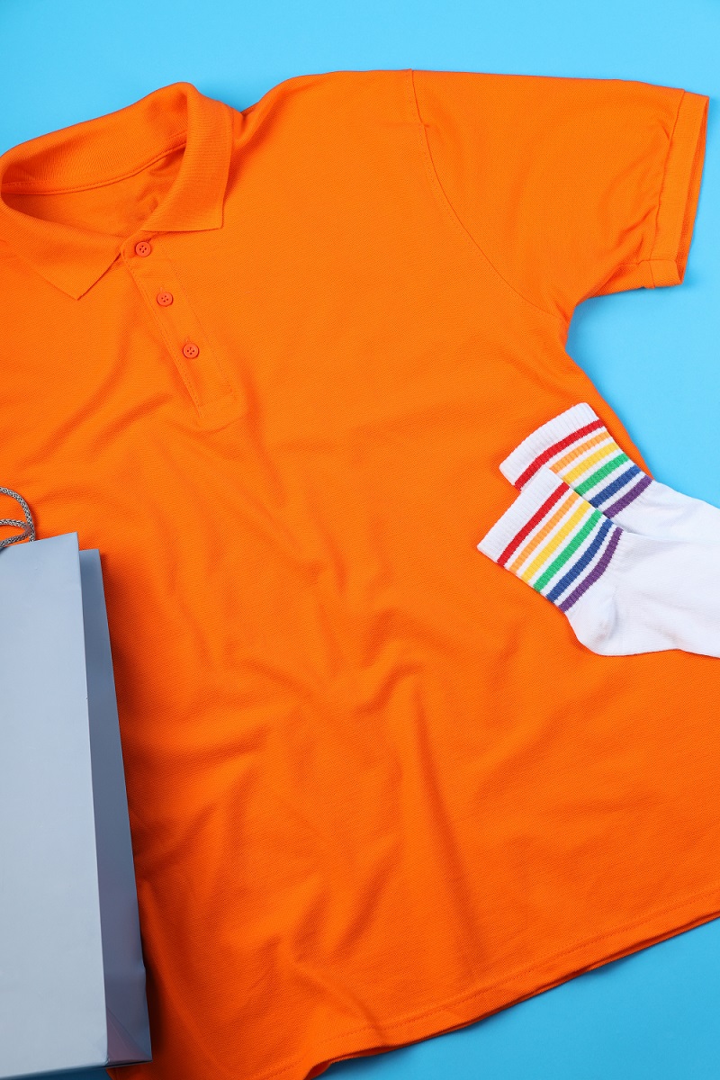 Blank t-shirt, bag and socks on blue background